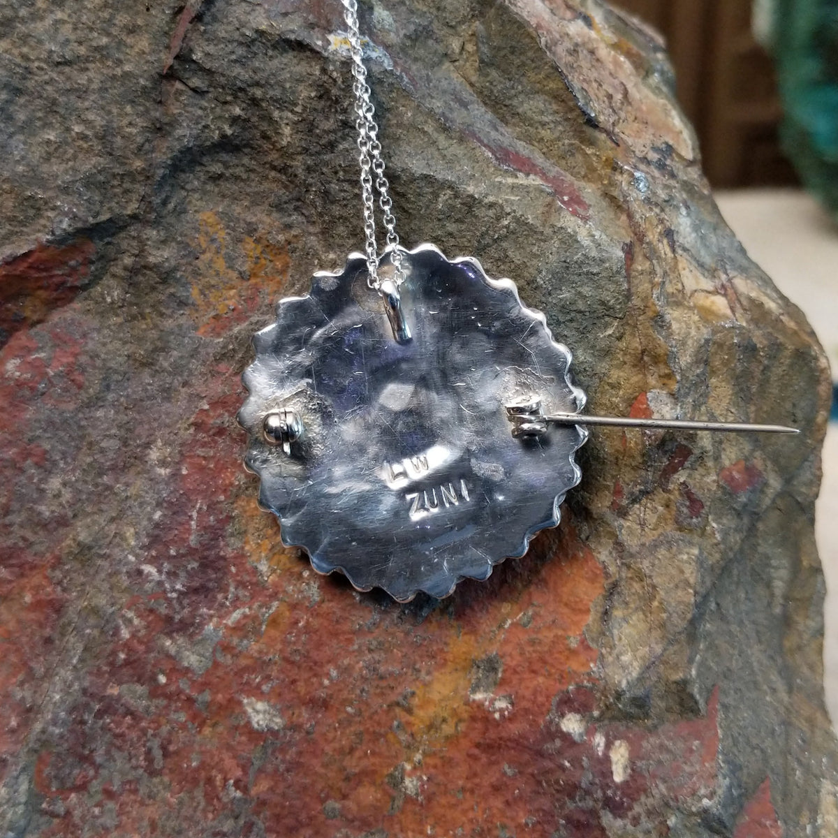 Zuni lapis cluster pendant and pin by Lorraine Waatsa featuring deep blue lapis stones arranged in concentric circles with twisted and sculptural silver detailing; artisan and tribe stamp.
