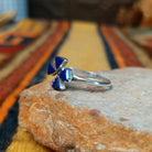 Zuni Lapis Dragonfly Ring featuring four triangular deep blue lapis lazuli inlay stones forming dragonfly wings, accented with sterling silver beads and a slender silver band; side view.