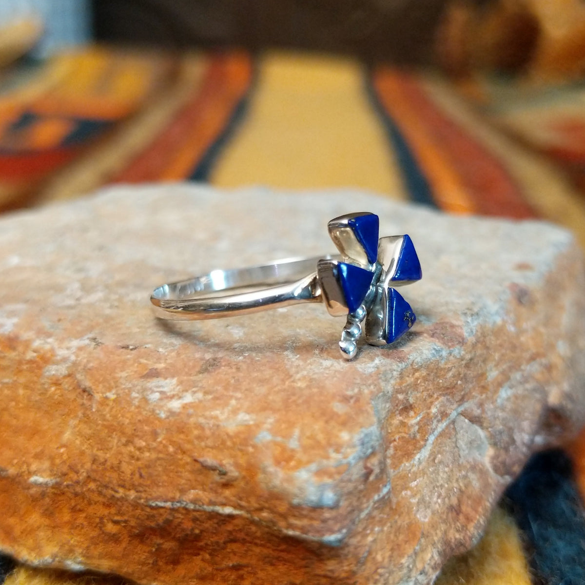 Zuni Lapis Dragonfly Ring featuring four triangular deep blue lapis lazuli inlay stones forming dragonfly wings, accented with sterling silver beads and a slender silver band; side view.