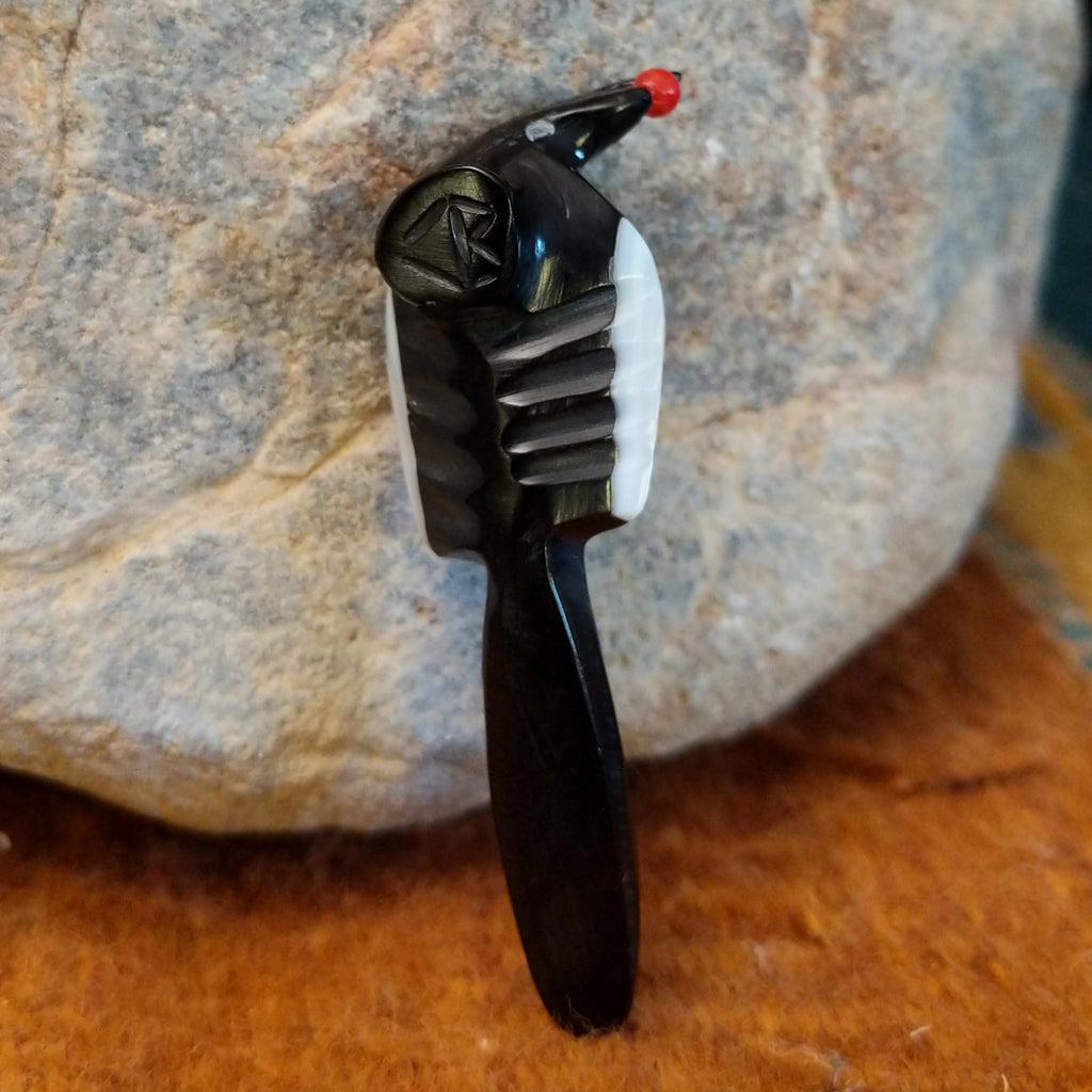 The artisan's signature is carved into the underside of the piece.