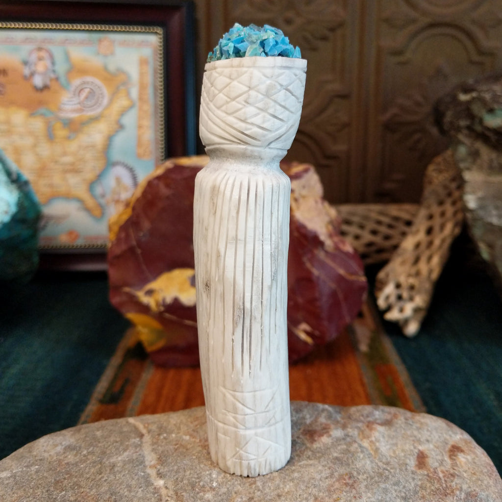 Zuni maiden fetish carving made from antler, with turquoise, mother of pearl, black onyx, and coral enhancing the carving's detailed texture.