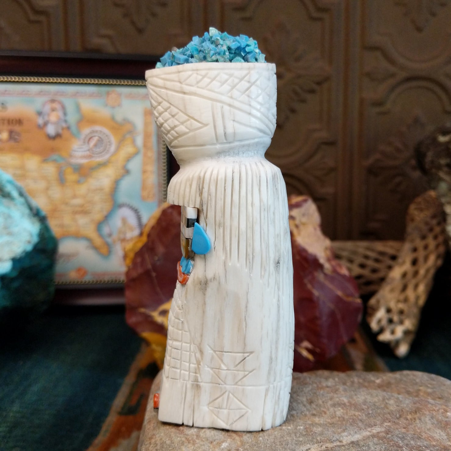 Zuni maiden fetish carving made from antler, with turquoise, mother of pearl, black onyx, and coral enhancing the carving's detailed texture.