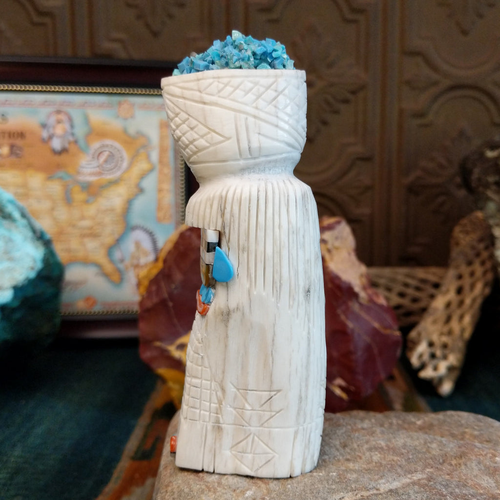 Zuni maiden fetish carving made from antler, with turquoise, mother of pearl, black onyx, and coral enhancing the carving's detailed texture.