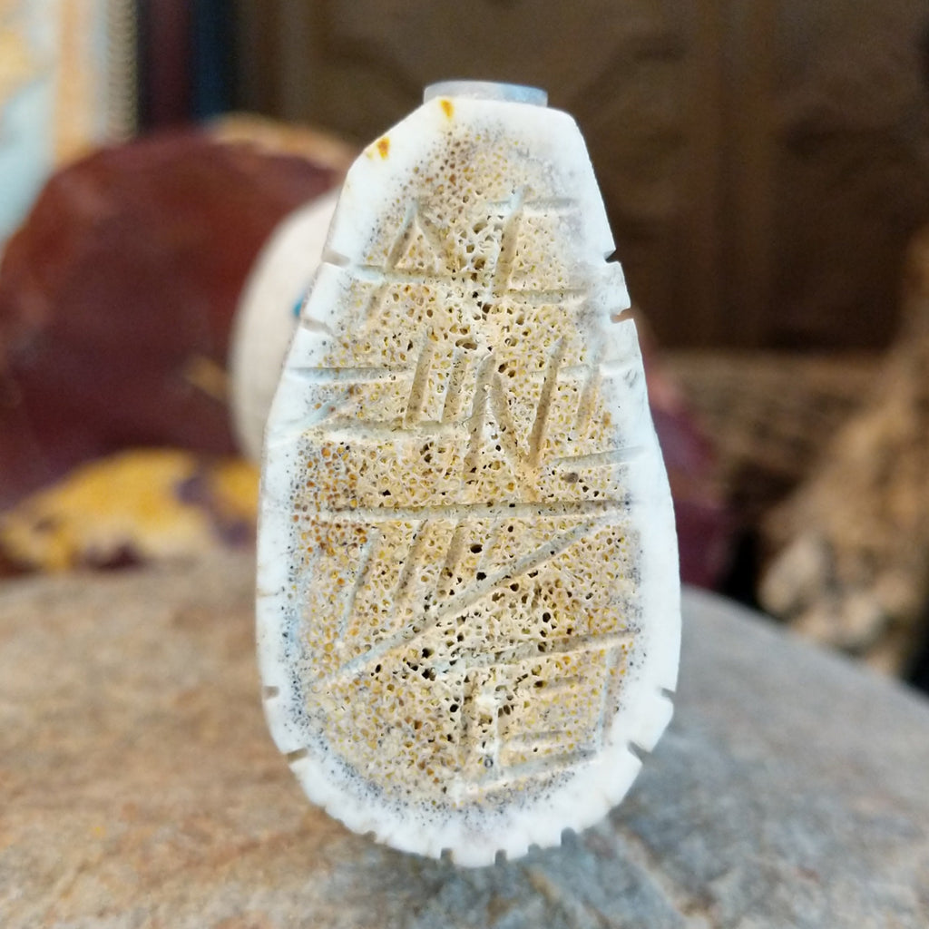 The artisan's signature is found on the underside of the piece.