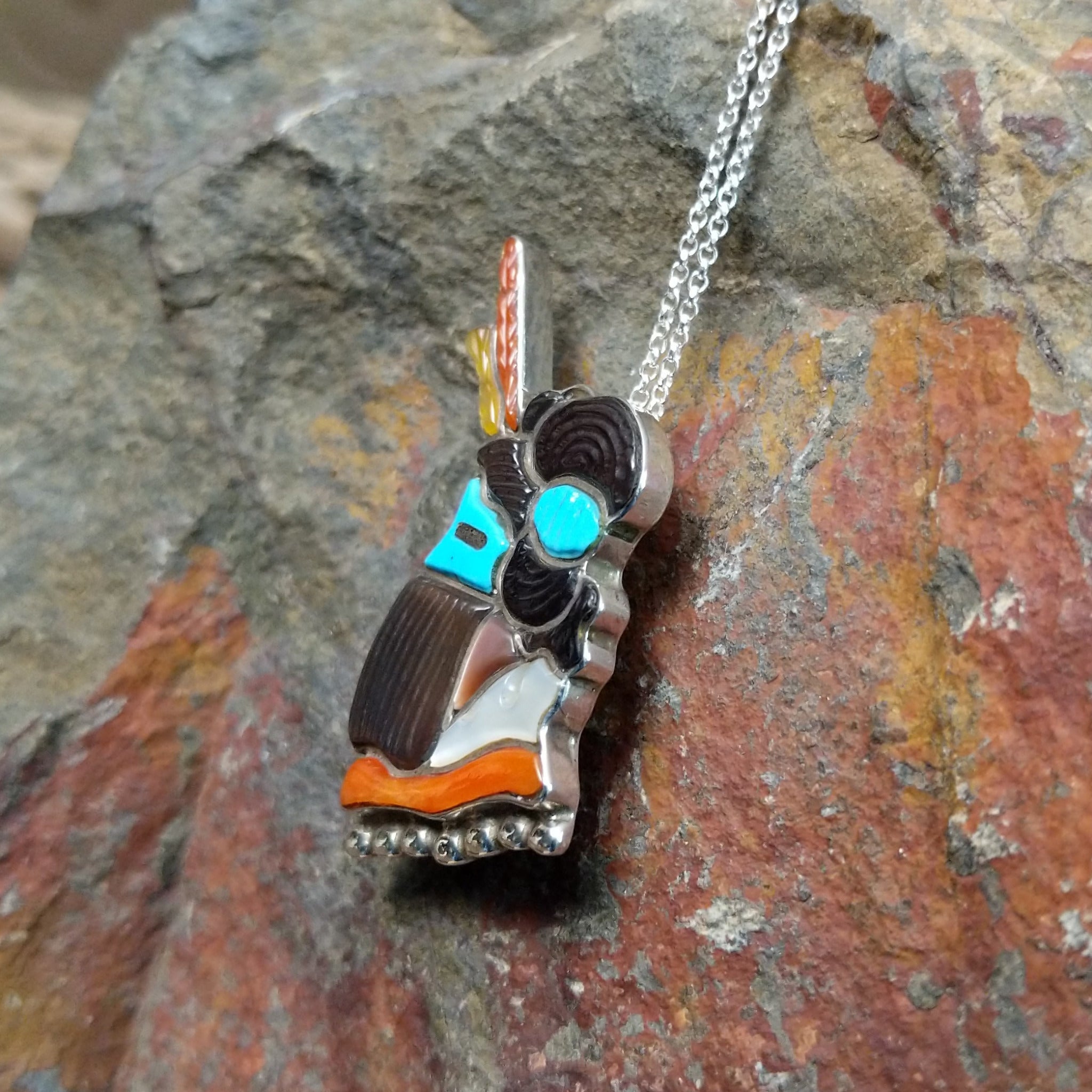 Handcrafted sterling silver Zuni Maiden pin and pendant by Andrea Shirley Lonjose, featuring intricate multistone inlay in a traditional Maiden design; side view.