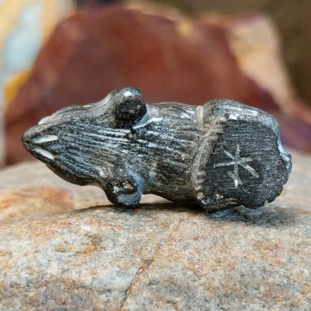 The underside of the piece features the artisan's signature.