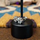 Handcrafted Zuni sterling silver flower earrings by Aaron Lasiloo featuring iridescent mother of pearl inlay in a delicate floral design with polished silver detailing.; side view.