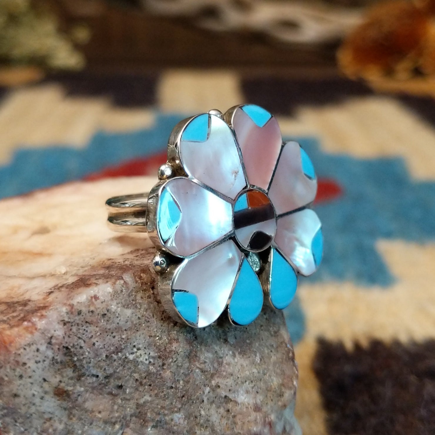 Sterling silver ring with multistone inlay of pink mussel shell, turquoise, black onyx, and coral.