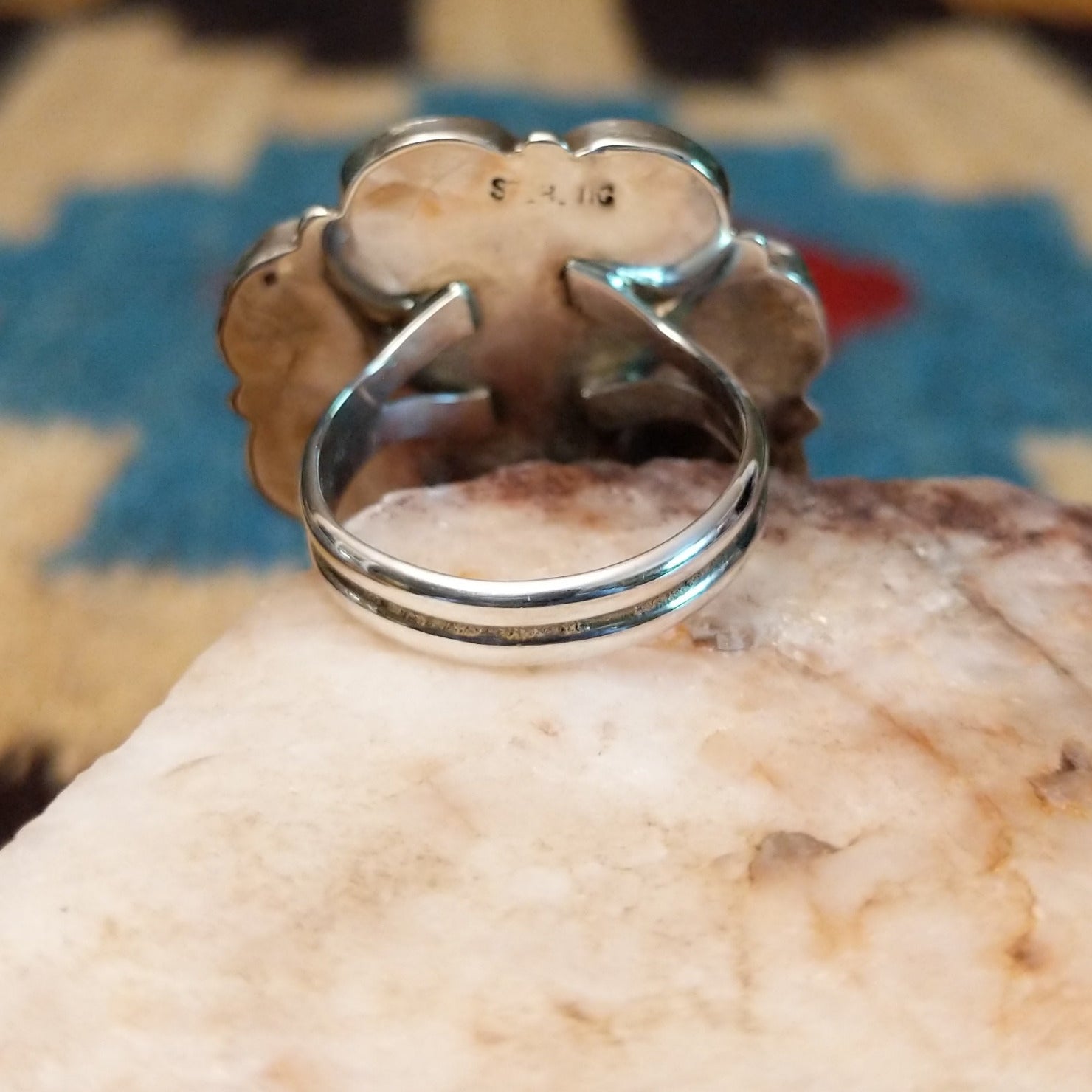 Sterling silver ring with multistone inlay of pink mussel shell, turquoise, black onyx, and coral.