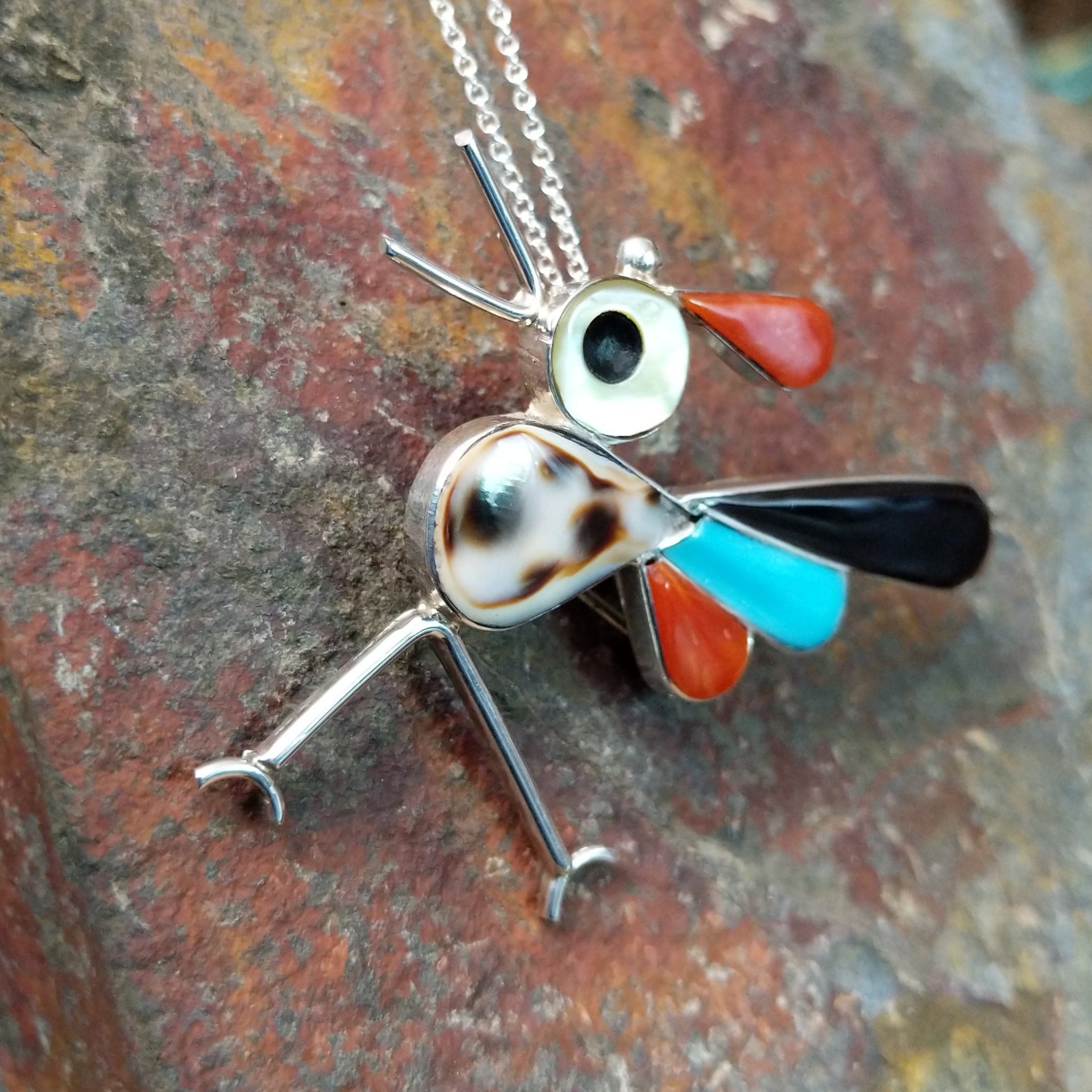 Handcrafted sterling silver multistone roadrunner pin and pendant by K.E., featuring traditional Zuni stone inlay in a colorful bird design; side view.