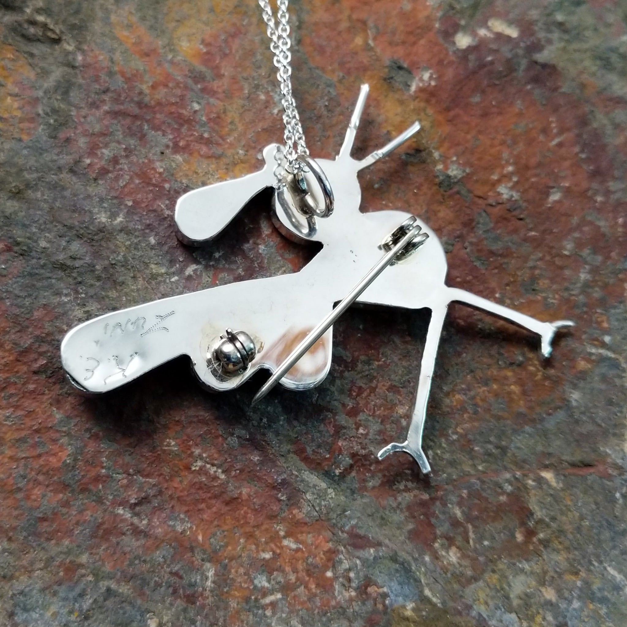 Handcrafted sterling silver multistone roadrunner pin and pendant by K.E., featuring traditional Zuni stone inlay in a colorful bird design; artisan signature.