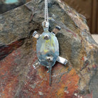 Zuni multistone turtle pendant and pin by W.J.H. featuring colorful turquoise, red-orange, black, and cream inlay set in a detailed silver turtle design; artisan initials.