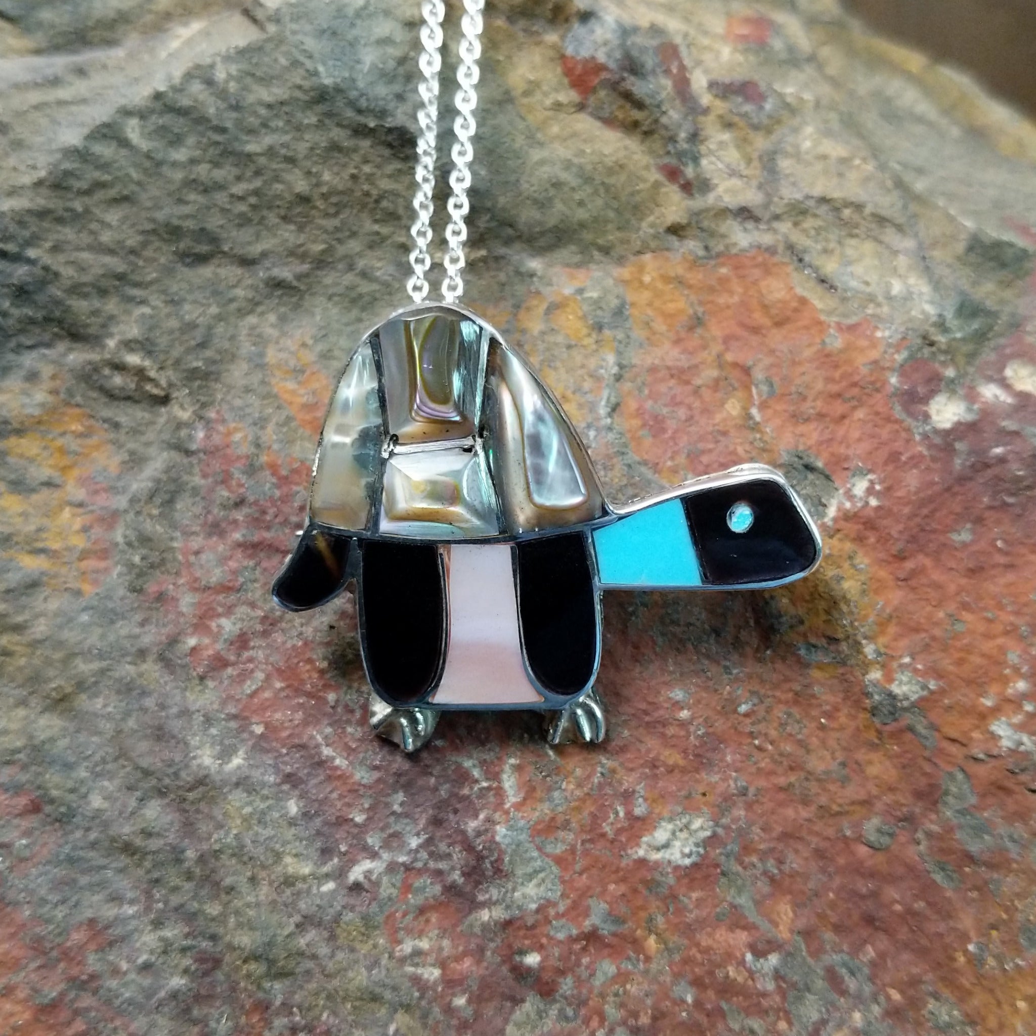 Handcrafted sterling silver multistone turtle pin and pendant by Lorretta, featuring traditional Zuni stone inlay in a turtle design.