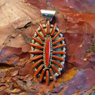Sterling silver pendant with coral needlepoint design.