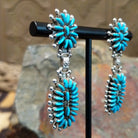 Handcrafted sterling silver Zuni needlepoint turquoise concho earrings by Connie Wyaco, featuring a two-piece dangle design with vibrant turquoise needlepoint; side view.