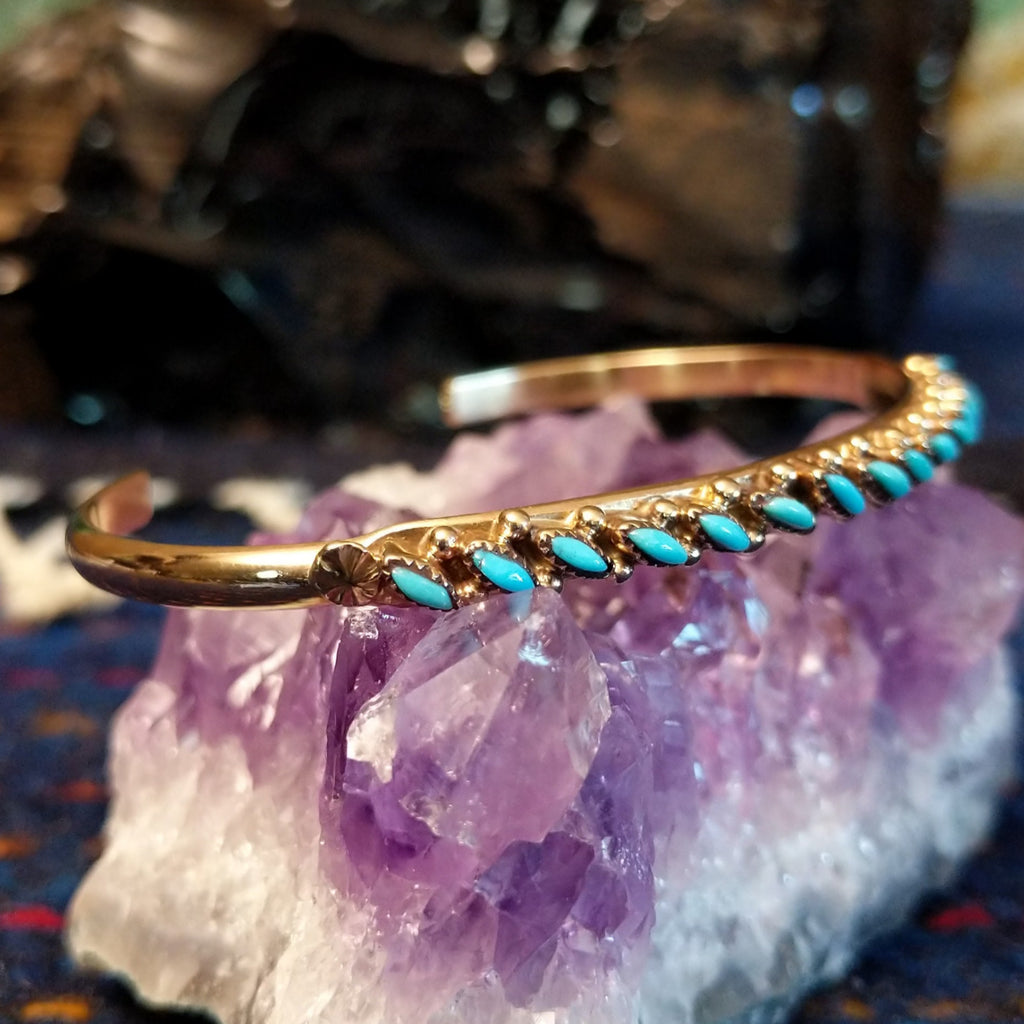 Zuni needlepoint turquoise cuff featuring the intricate design and gold beading.