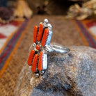 Sterling silver ring with coral set in seven bezels, featuring dot work and a thin band.