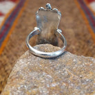 Sterling silver ring with coral set in seven bezels, featuring dot work and a thin band.