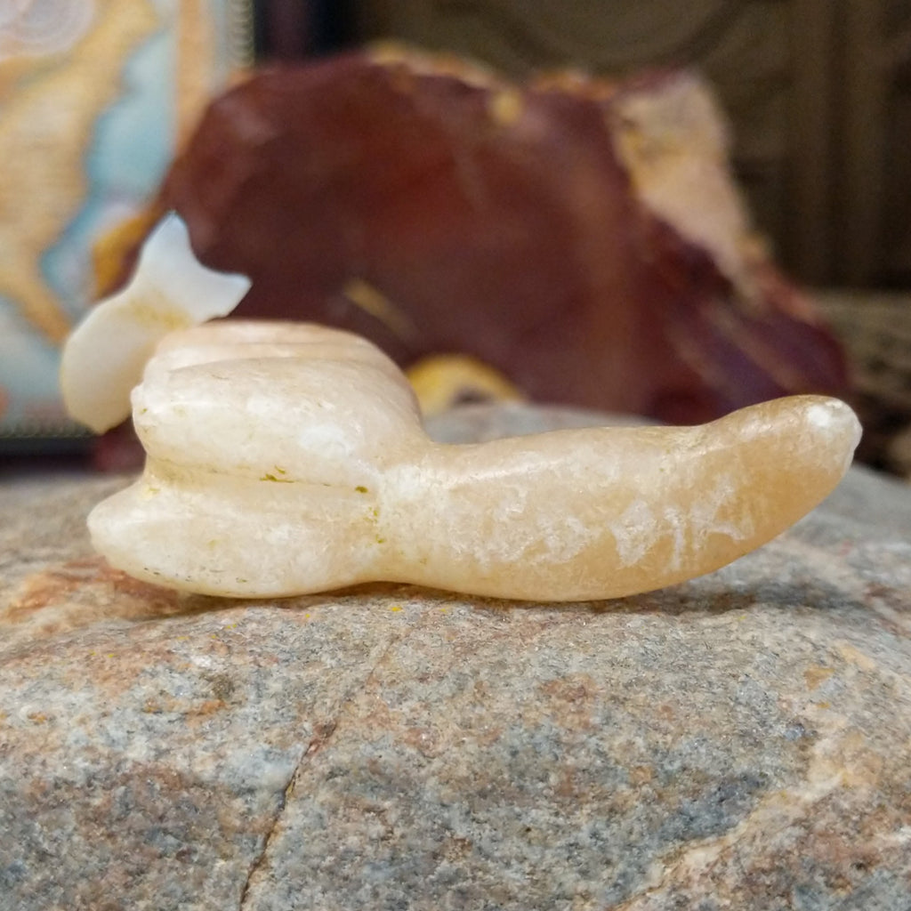 The artisan's signature is carved into the base of the tail.