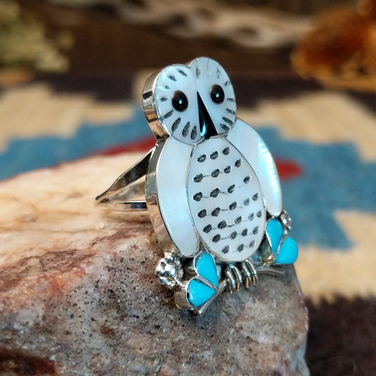 Sterling silver ring with mother of pearl, turquoise, and black onyx inlaid to create the owl motif.