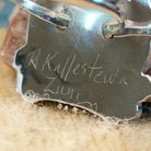 Close-up of the artisan's stamped signature.