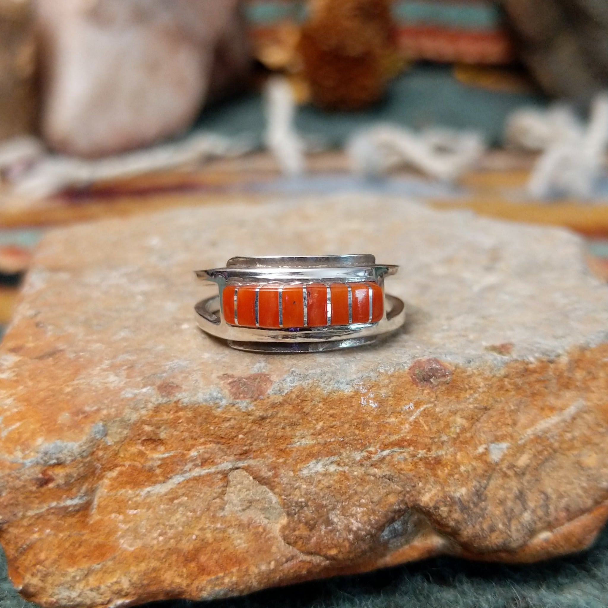 Zuni sterling silver ring by Lindsay Von-Tsalate featuring raised coral inlay with silver dividers in a polished open-band setting.