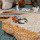 Zuni sterling silver ring by Lindsay Von-Tsalate featuring raised coral inlay with silver dividers in a polished open-band setting; side view.