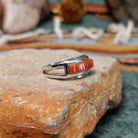 Zuni sterling silver ring by Lindsay Von-Tsalate featuring raised coral inlay with silver dividers in a polished open-band setting; side view.