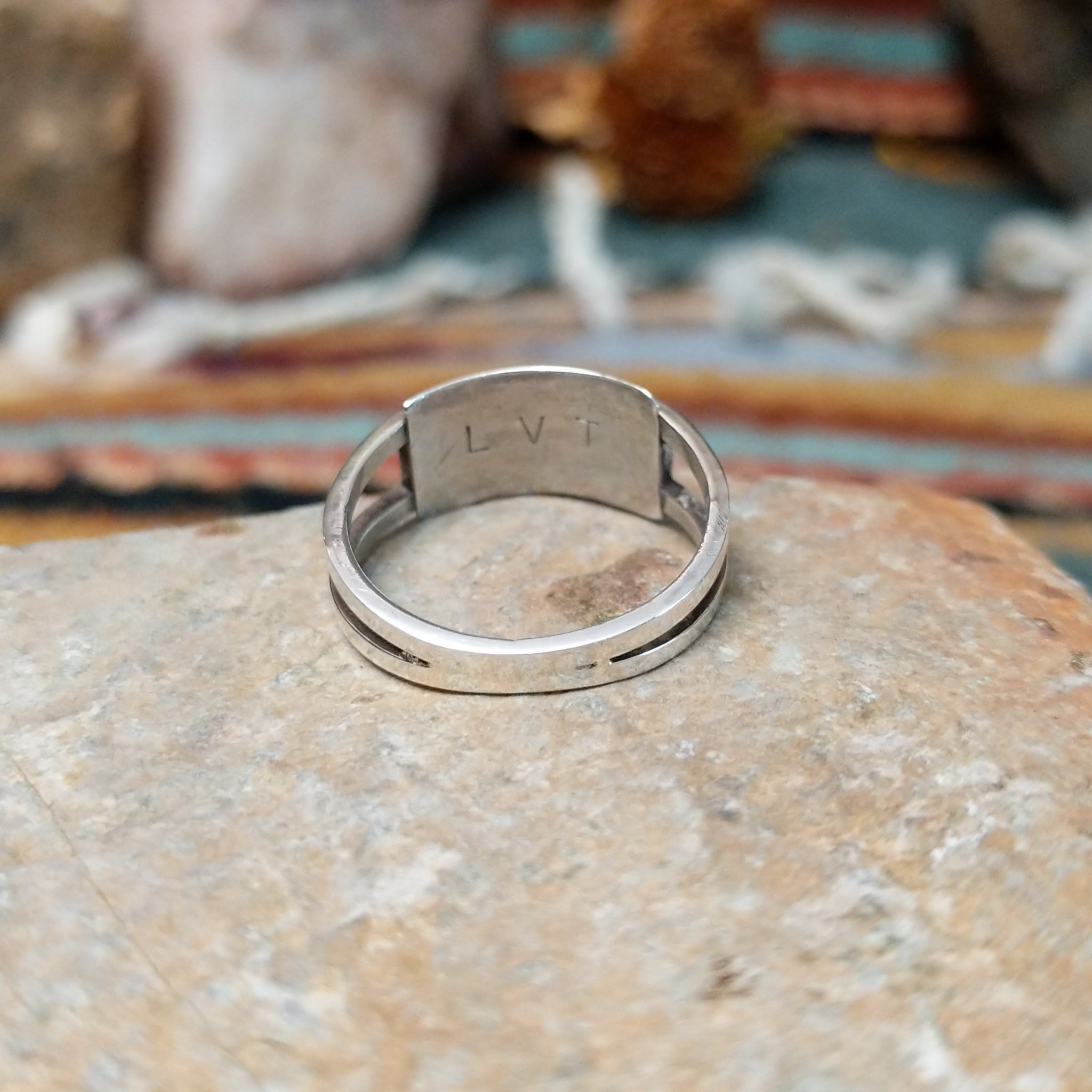 Zuni sterling silver ring by Lindsay Von-Tsalate featuring raised coral inlay with silver dividers in a polished open-band setting; underside view.