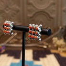 Sterling silver earrings with coral set in notched bezels, arranged in a square formation.