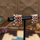 Sterling silver earrings with coral set in notched bezels, arranged in a square formation.