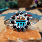 Zuni Sunface cuff by D., featuring a traditional Sunface design with intricate inlay work and handcrafted Southwestern-inspired metalwork.