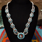 Zuni Sunface Sterling Silver necklace by Marisa Selecion, featuring turquoise, coral, black onyx, and mother of pearl, with detailed Sunface designs.