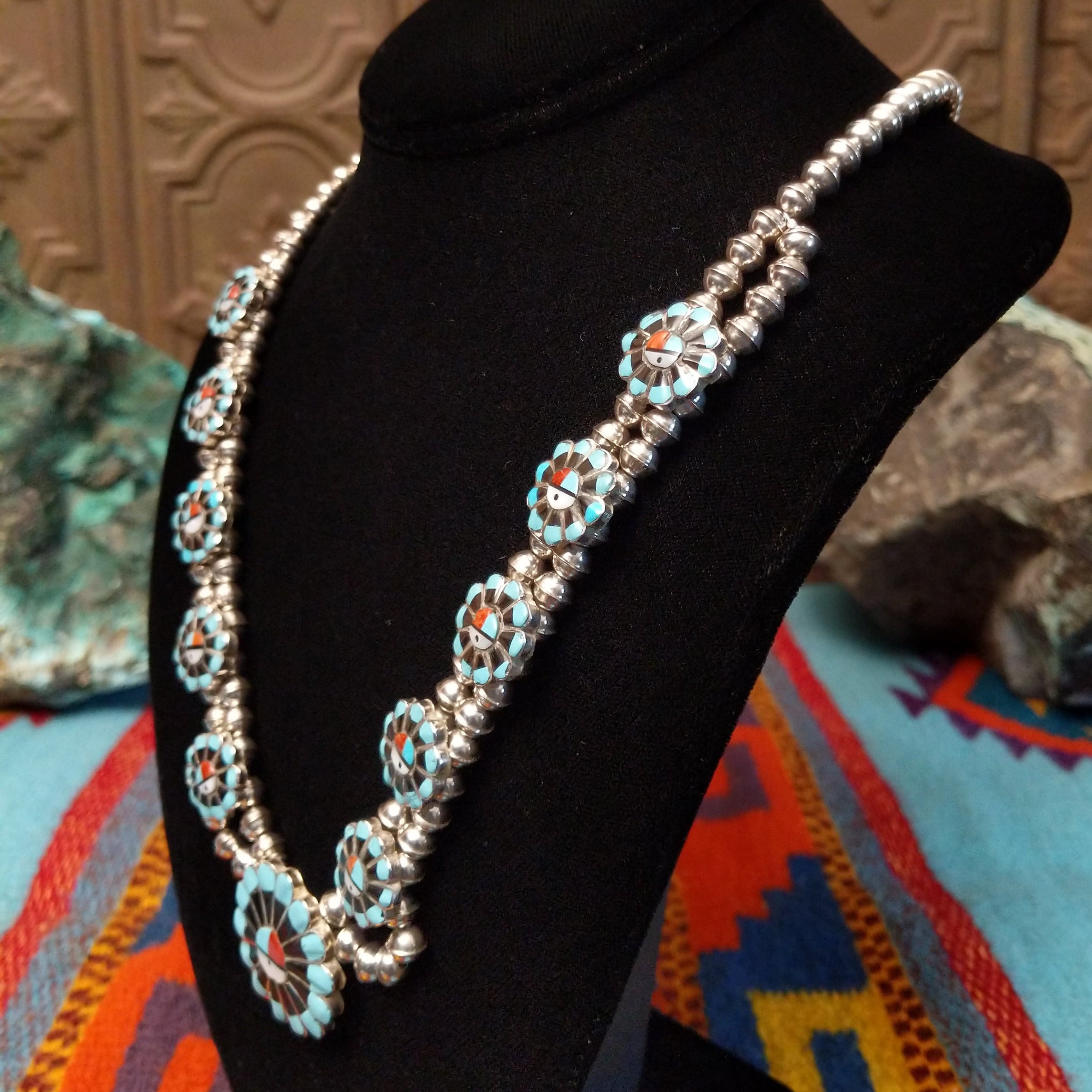 Zuni Sunface Sterling Silver necklace by Marisa Selecion, featuring turquoise, coral, black onyx, and mother of pearl, with detailed Sunface designs; side view.