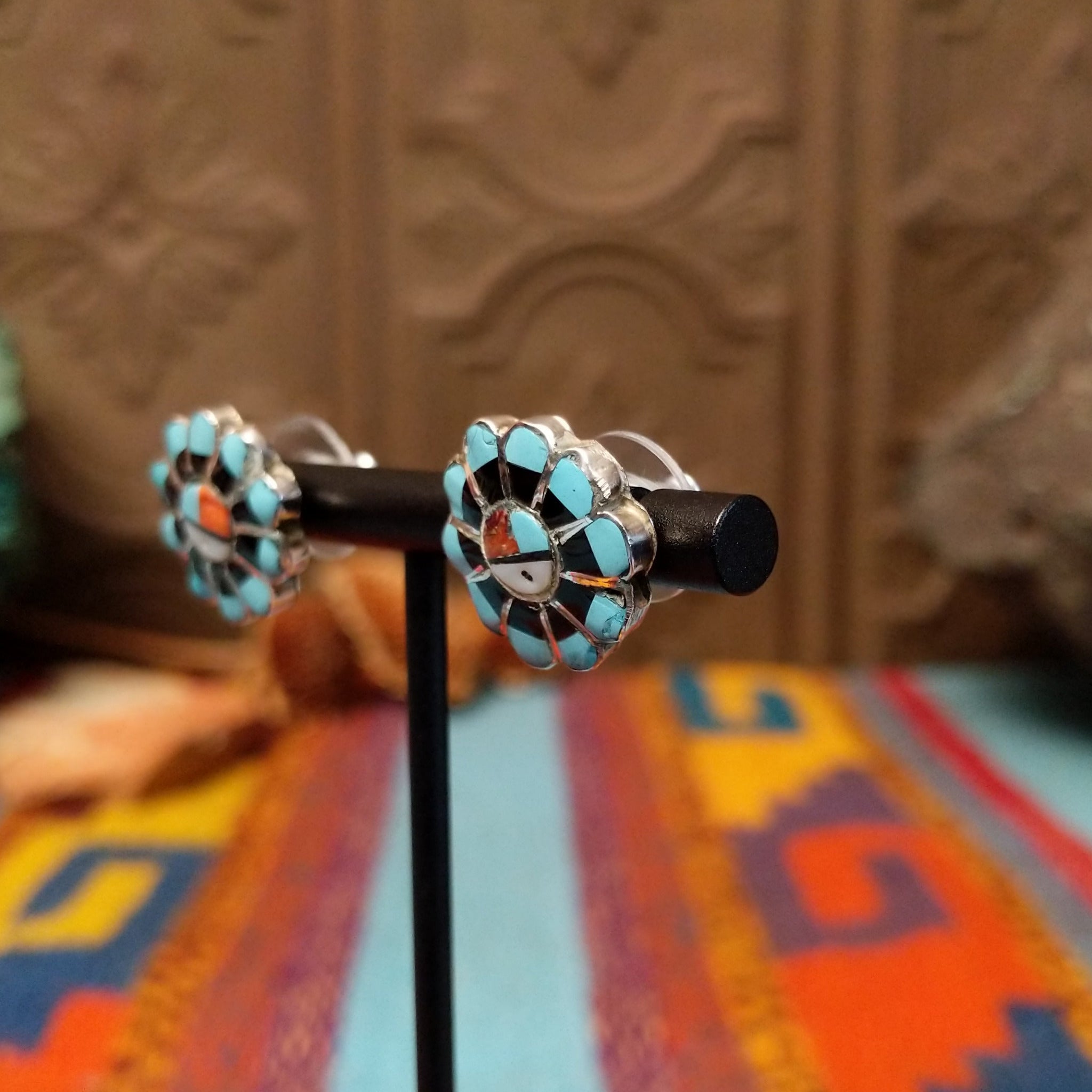 Zuni Sunface Sterling Silver earrings by Marisa Selecion, featuring turquoise, coral, black onyx, and mother of pearl, with detailed Sunface designs; side view.