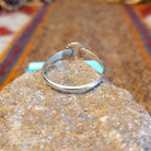 Sterling silver ring with sunface design crafted with turquoise, mother of pearl, black onyx, and coral that is framed by twisted rope detailing.