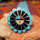 Zuni Sunface Ring by Annie Willie featuring an intricate multicolor inlay Sunface design with turquoise, black, red, and cream-colored accents set in Sterling Silver.