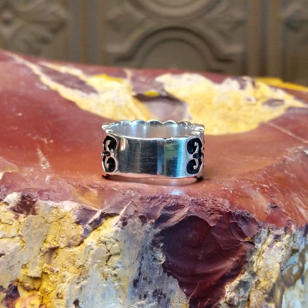 Sterling silver ring with symmetrical geometric patterns all along the band.