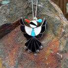 Zuni Thunderbird pendant and pin by Leagus Ahiyite featuring black, white, turquoise, and red stone inlay in a detailed silver Thunderbird design.