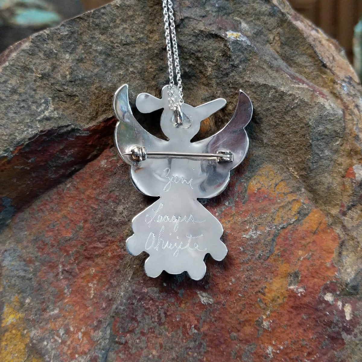 Zuni Thunderbird pendant and pin by Leagus Ahiyite featuring black, white, turquoise, and red stone inlay in a detailed silver Thunderbird design; artisan and tribe signature.