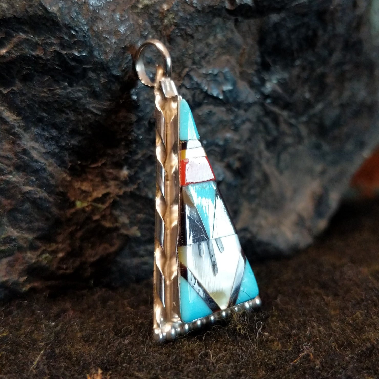 Various stones inlaid in a triangular sterling silver bezel.
