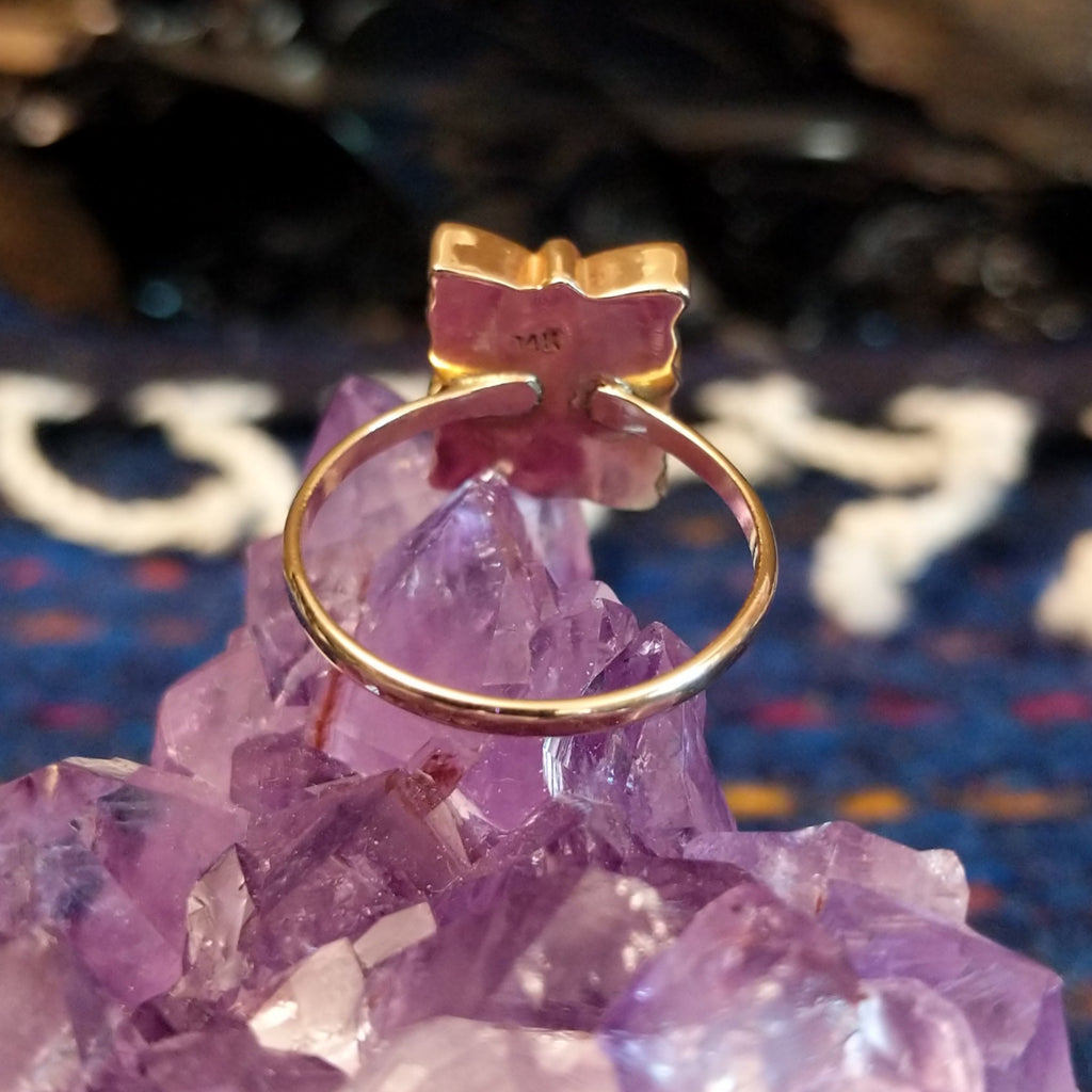 The thin gold band of the ring.