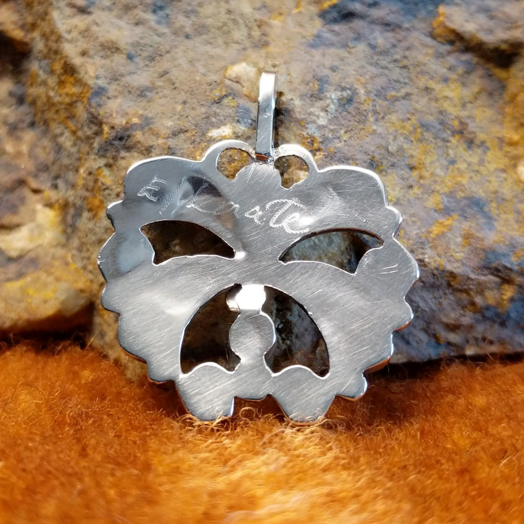 The artisan's stamped signature is found on the back of the pendant.