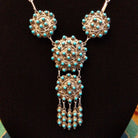 Sterling silver link necklace with drop cluster pendants and turquoise set in notched bezels.