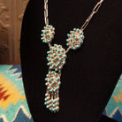 Sterling silver link necklace with drop cluster pendants and turquoise set in notched bezels.