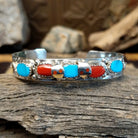 Sterling silver bracelet with turquoise and coral set in notched bezels, featuring the snake design.