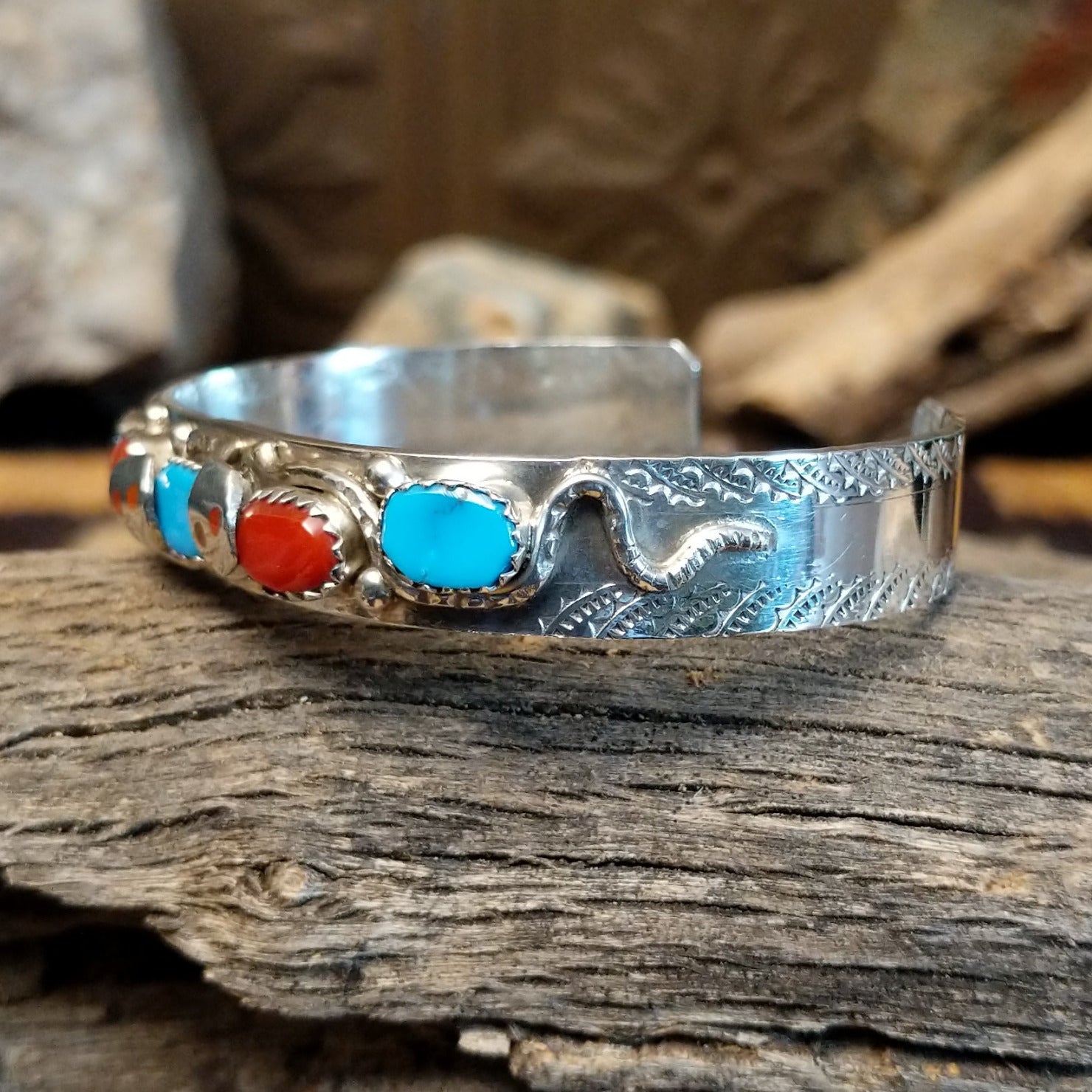 Sterling silver bracelet with turquoise and coral set in notched bezels, featuring the snake design.