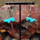 Dangle earrings feature carved Zuni turquoise bears with pen shell heishi beads, strung on sterling silver wire.