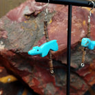 Dangle earring featuring a carved Zuni turquoise bear with pen shell heishi beads, strung on sterling silver wire.