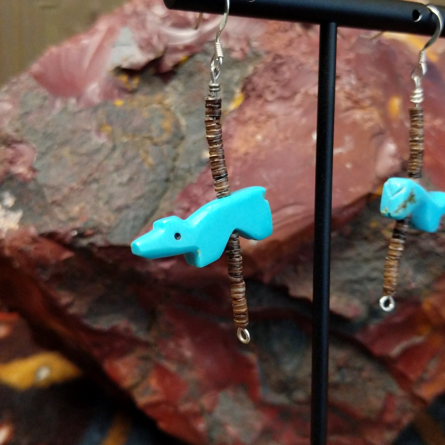 Dangle earring featuring a carved Zuni turquoise bear with pen shell heishi beads, strung on sterling silver wire.